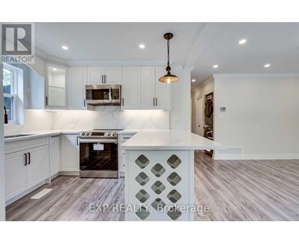 A kitchen with white cabinets and a wooden floor.
