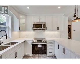 A modern kitchen with white cabinets and a stove top oven.