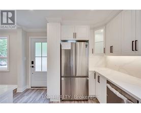 A kitchen with white cabinets and a stainless steel refrigerator.