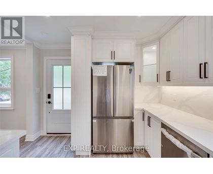 A kitchen with white cabinets and a stainless steel refrigerator.