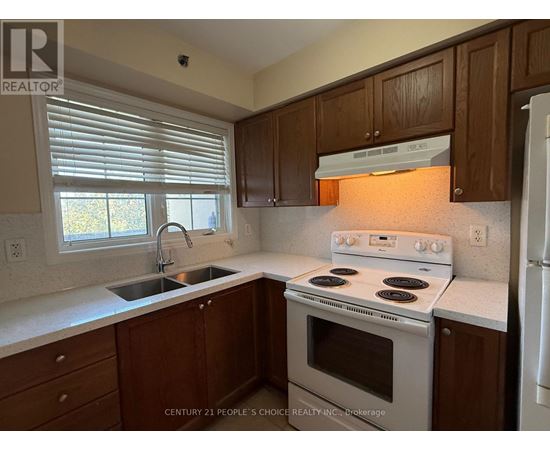 A kitchen with wooden cabinets and a white stove top oven.
