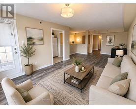 A living room with a beige couch, a coffee table, and a plant.