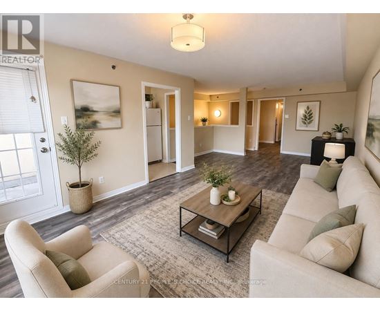 A living room with a beige couch, a coffee table, and a plant.
