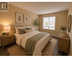 A bedroom with a bed, nightstands, and a plant.