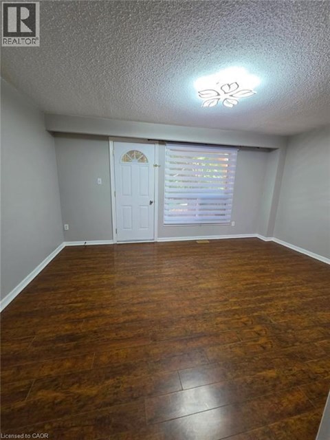 A room with wood flooring and a white door.