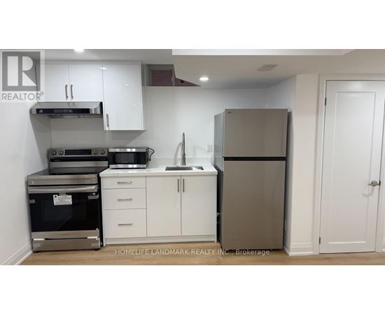A kitchen with white cabinets and a stainless steel refrigerator.
