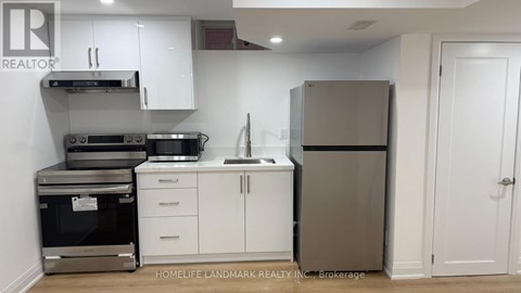 A kitchen with white cabinets and a stainless steel refrigerator.