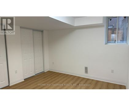 A room with a white wall and a wooden floor.