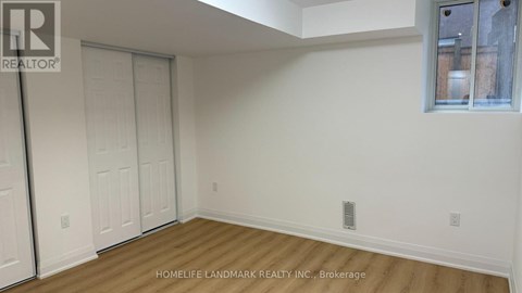 A room with a white wall and a wooden floor.