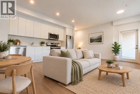 A living room with a couch, a table, and a chair.