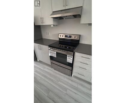 A kitchen with a stove top oven and a range hood.