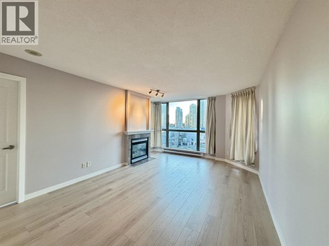 A spacious living room with a fireplace and a view of the city.