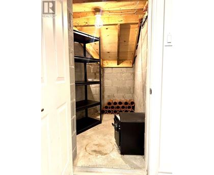 A room with exposed ceiling beams and a wooden floor.