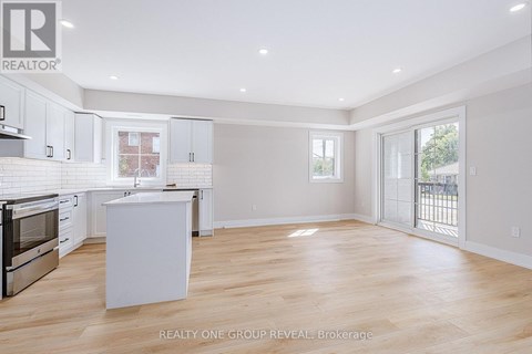 A spacious kitchen with white cabinets and a wooden island.