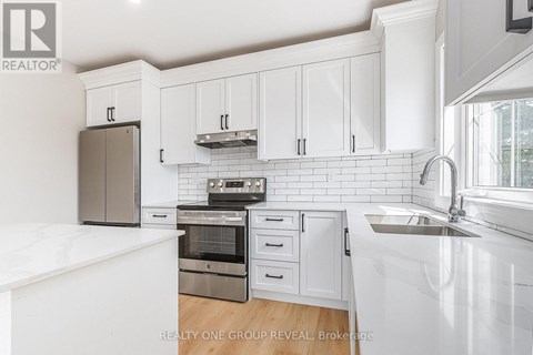 A white kitchen with a sink and cabinets.