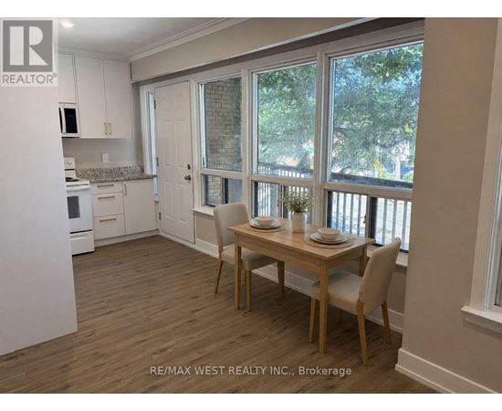 A dining room with a table set for two with a view of the backyard.