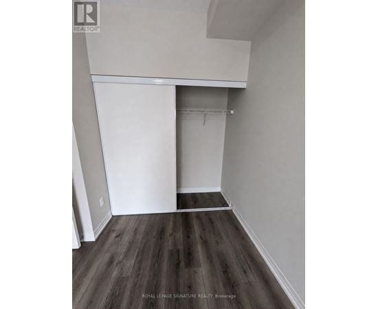 A room with a white closet and wooden floors.