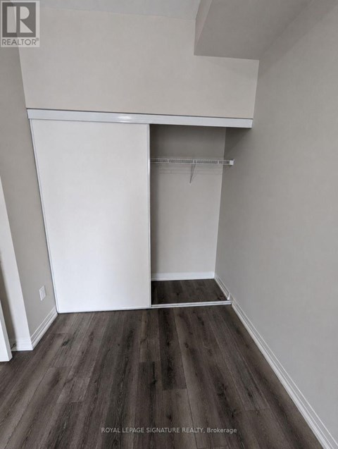 A room with a white closet and wooden floors.