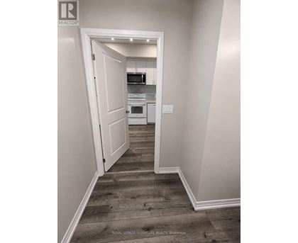 A hallway with a doorway leading to a kitchen.