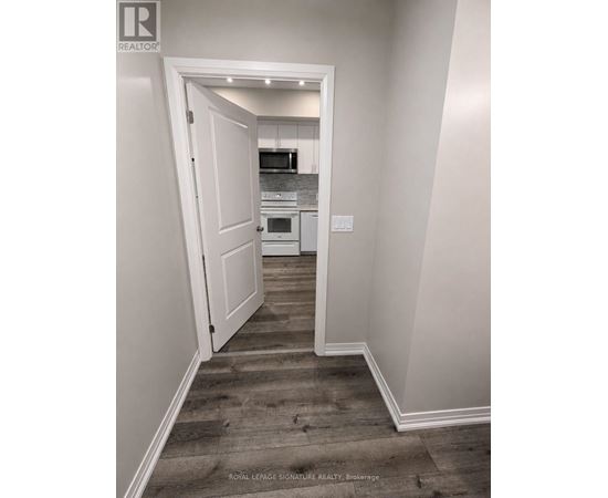 A hallway with a doorway leading to a kitchen.