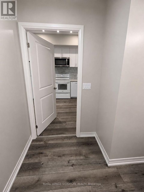 A hallway with a doorway leading to a kitchen.