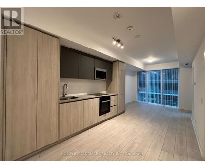 A modern kitchen with wooden cabinets and a microwave above the stove.