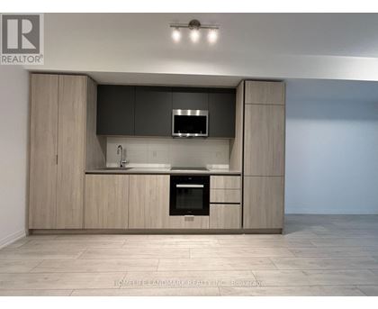 A modern kitchen with wooden cabinets and a stainless steel oven.