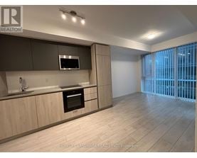 A modern kitchen with wooden cabinets and a stainless steel oven.