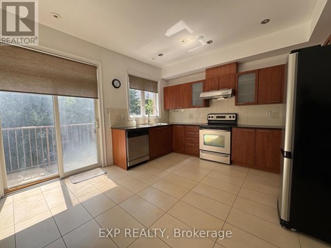 A kitchen with wooden cabinets and a black refrigerator.