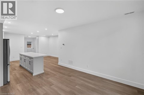 A spacious room with a wooden floor and a white wall.