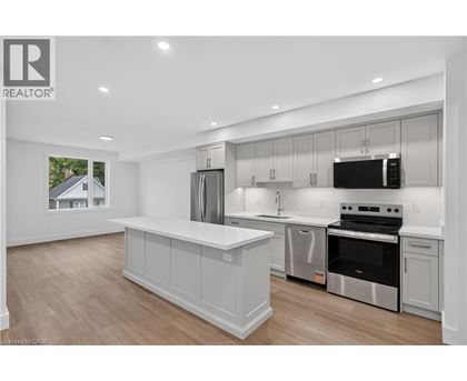A modern kitchen with a large island and stainless steel appliances.