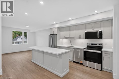 A modern kitchen with a large island and stainless steel appliances.