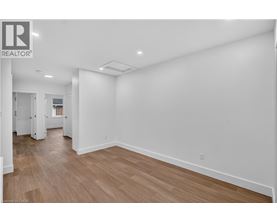 A large empty room with wooden floors and white walls.