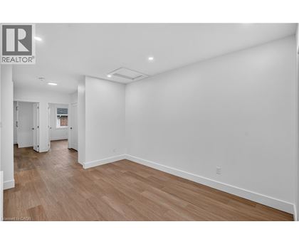 A large empty room with wooden floors and white walls.