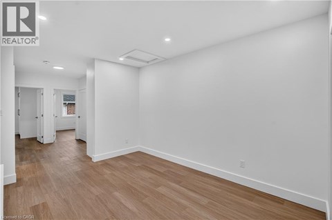 A large empty room with wooden floors and white walls.