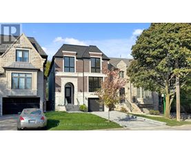 A row of houses with a car parked in front of the first one.