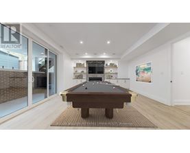 A pool table is in the middle of a room with a glass wall.