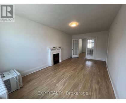A room with a fireplace and wood flooring.