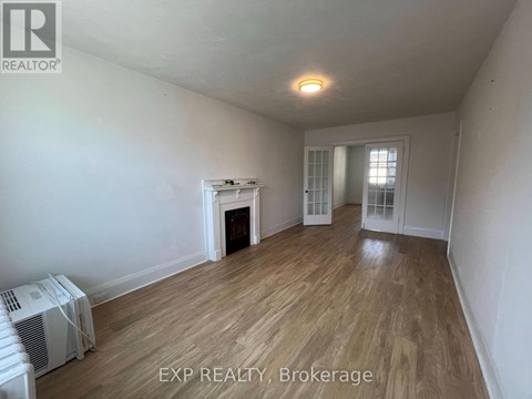 A room with a fireplace and wood flooring.