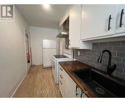 A kitchen with white cabinets and a black sink.