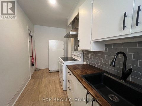 A kitchen with white cabinets and a black sink.