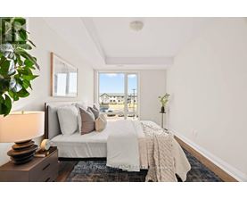 A bedroom with a large bed and a view of the outside through a window.