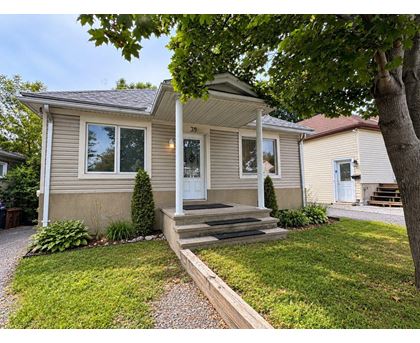 A house with a front porch and a tree in front.