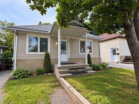 A house with a front porch and a tree in front.