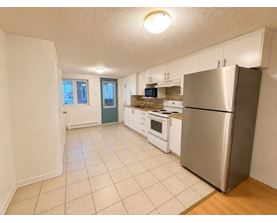 A kitchen with a refrigerator, oven, and microwave.