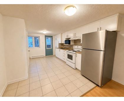 A kitchen with a refrigerator, oven, and microwave.