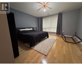 A bedroom with a bed, a ceiling fan, and a rug.