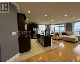 A modern kitchen with dark wood cabinets and a large island.