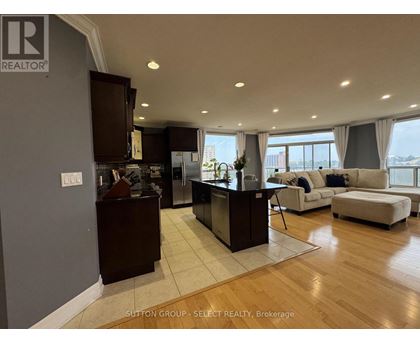A modern kitchen with dark wood cabinets and a large island.