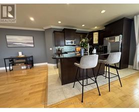 A modern kitchen with dark wood cabinets and a bar area.